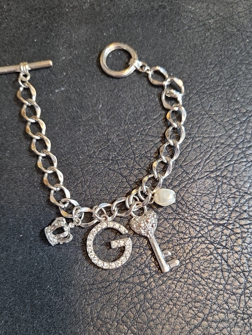 Guess Silver Tone Charm Bracelet with G Initial, Key & Pearl And Crown Accent
